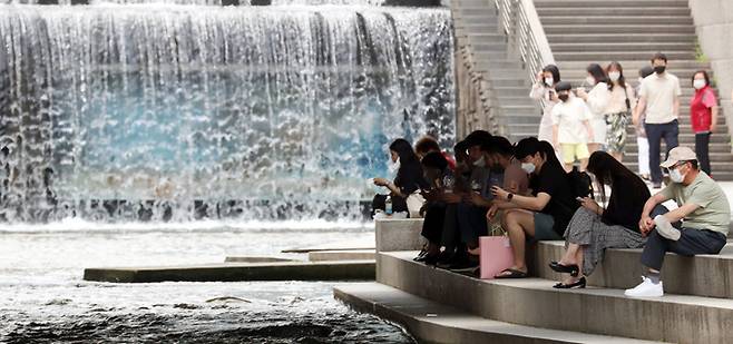 14일 서울 낮 기온 30도 등 전국이 30도 안팎의 날씨를 보인 가운데 서울 중구 청계천 모전교 아래에서 시민들이 태양을 피해 휴식을 취하고 있다. 뉴스1