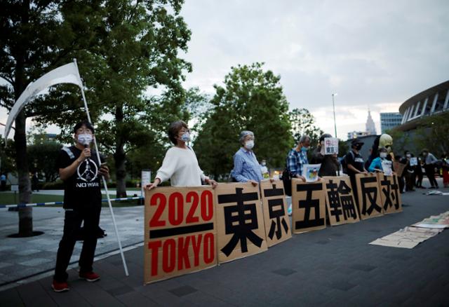 도쿄올림픽 개최를 반대하는 시위대가 14일 일본 도쿄의 일본올림픽위원회(JOC) 본부 주변에서 집회를 열고 있다. 도쿄=로이터 연합뉴스