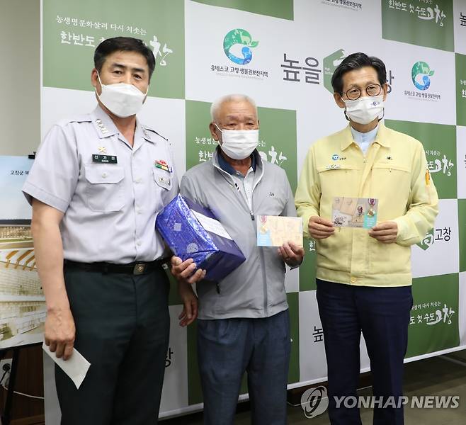 고 홍인수 이등중사의 아들 홍순옥 씨 무공훈장 전달식 (서울=연합뉴스) 권선미 기자 = 지난 2일 전북 고창군수 군수실에서 고 홍인수 이등중사의 아들 홍순옥(71) 씨가 아버지의 무공훈장과 6.25 무공훈장 찾아주기 조사단에서 제작한 엽서를 들고 서 있다. 왼쪽부터 조사단장 신기진 대령, 홍순옥 씨, 유기상 고창군수.