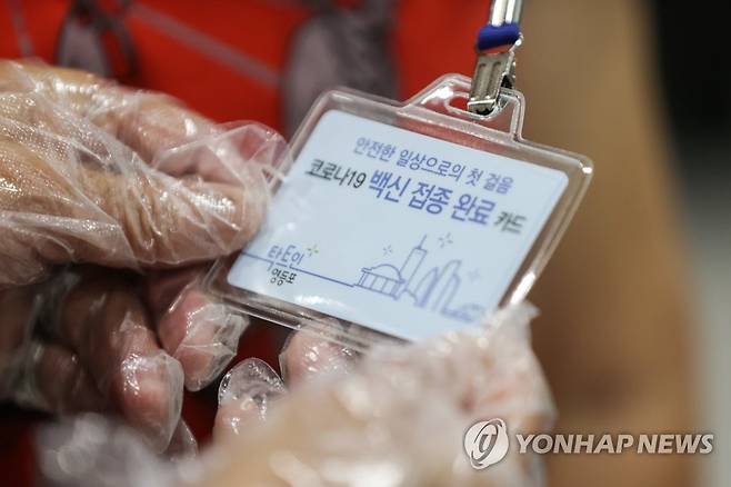 영등포구, 백신 접종 완료 카드 지급 (서울=연합뉴스) 임화영 기자 = 17일 오전 서울 영등포구 영등포아트홀에 마련된 코로나19 예방접종센터에서 한 어르신이 백신 접종 완료 카드를 보고 있다.       영등포구는 이날부터 2차 접종까지 마친 만 65세 이상 주민에게 백신 접종 완료 기념 카드를 배부한다고 밝혔다. 단, 해당 카드는 예방접종증명서를 대체하지 않지만, 향후 공공시설에서 사용이 가능하도록 관계부서와 협의할 예정이라고 덧붙였다. 2021.6.17 hwayoung7@yna.co.kr