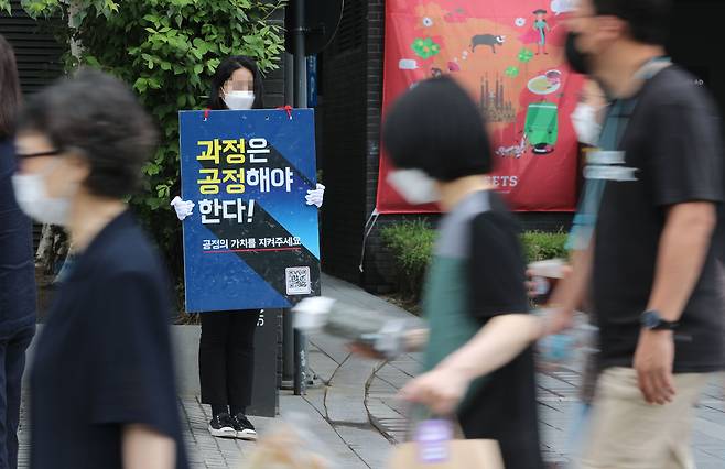 18일 '사무논의협의회'가 열린 서울 여의도의 한 호텔 앞에서 국민건강보험공단의 한 정규직 직원이 고객센터(콜센터) 직원들의 공단 직접 고용을 반대하며 1인 시위를 하고 있다. /오종찬 기자