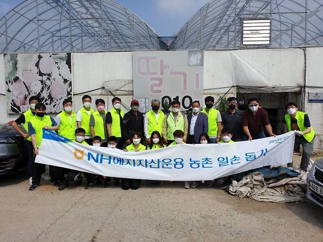 이동훈 NH헤지자산운용 대표(뒷줄 왼쪽 칠곱번째)와 영일딸기농장 박기일 대표(뒷줄 왼쪽 여섯번째), 고촌농협 조동환 조합장(뒷줄 오른쪽 다섯번째), 김포시지부 권오현 지부장(뒷줄 오른쪽 네번째) 등이 임직원들과 기념촬영을 하고 있다.[사진=NH투자증권]