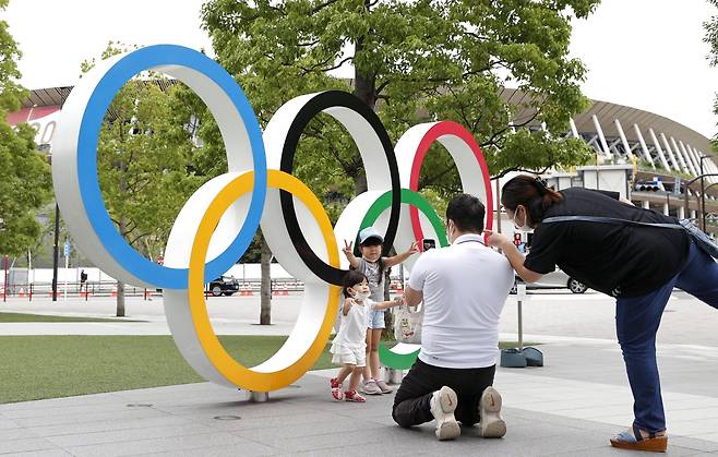 22일 시민들이 도쿄 국립경기장 올림픽 조형물을 배경으로 기념촬영을 하고 있다. 교도=연합뉴스
