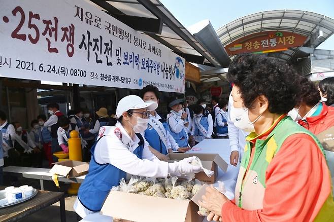청송군과 한국자유총연맹 청송군지부 회원들이 군민들에게 보리떡, 보리주먹밥을 나눠 주고 있다. (청송군 제공) 2021.06.24