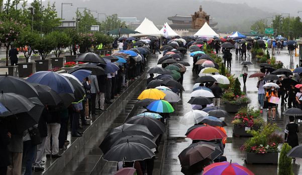 지난해 7월 13일 서울 광화문 광장에 마련된 백선엽 장군 추모 분향소에 추모를 위해 방문한 시민들이 우산을 쓰고 줄을 서 있다./이진한기자