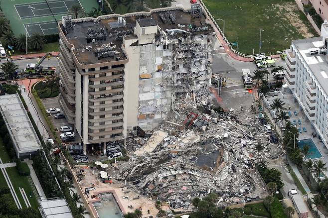 미국 플로리다주(州) 마이애미데이드카운티 서프사이드에서 24일(현지시간) 붕괴사고가 발생한 12층짜리 아파트를 공중에서 바라본 사진. 이 붕괴사고로 주민 1명이 숨지고 10명 이상이 부상했으며, 99명은 소재가 파악되지 않고 있다. AP/연합뉴스