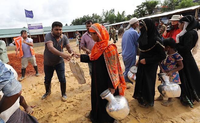 미얀마 라카인주에 살던 로힝야족 70여만명은 2017년 8월 미얀마군에 쫓겨 방글라데시로 탈출했다. 이듬해 6월 방글라데시 콕스바자르에 있는 한 난민촌에서 로힝야족들이 여성용 구호물품을 받고 있는 모습. 인도계인 로힝야족은 영국의 식민지 정책에 따라 미얀마에 대거 이주해 살다가 미얀마의 독립 이후 버마족들로부터 박해를 받아왔다. 콕스바자르/백소아 기자 thanks@hani.co.kr