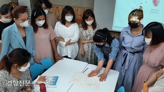 진은아 강사(오른쪽에서 세번째)가 지난 23일 서울 구로구  건강가정·다문화가족지원센터 강당에서 진행한 강의에서 참석자들에게 스케치법에 대해 설명하고 있다.  류인하 기자