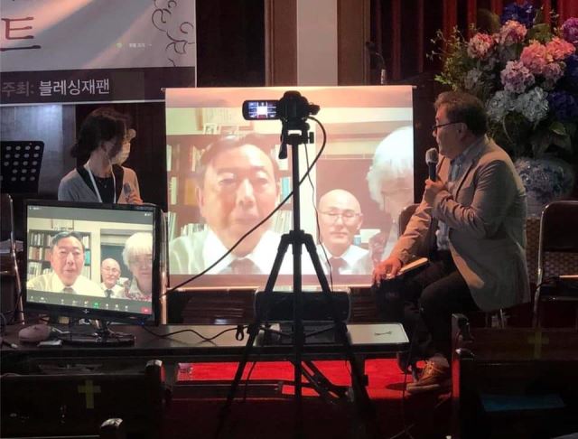 '사랑으로 잇다'의 저자 나카무라 사토시(TV화면 속 왼쪽)  목사와 번역자 박창수 선교사가 화면 속에 등장해 책에 대해 얘기하고 있다.