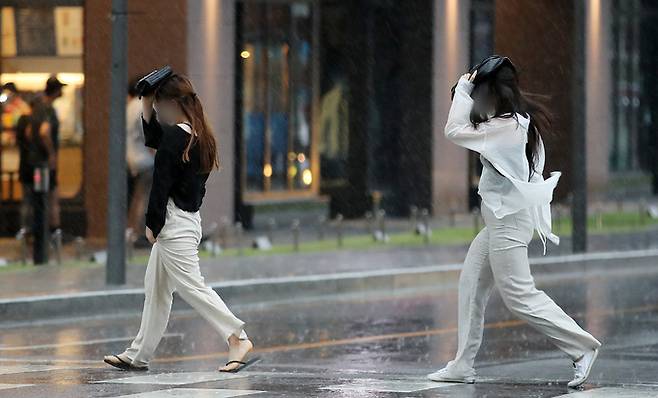 소나기가 내린 27일 오후 서울 종로구 종각역 인근 거리에서 시민들이 발걸음을 재촉하고 있다. 뉴스1
