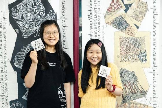 황승민(왼쪽) 학생기자·현지용 학생모델이 완성된 젠탱글 작품을 들어보였다. “젠탱글을 그리는 동안 다른 미술과 달리 ‘잘해야 한다’는 압박감이 느껴지지 않아 좋았다”고 소감을 전한 두 사람.