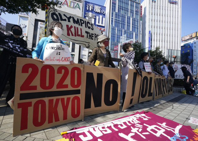 일본 시민들이 지난 23일 일본 도쿄 신주쿠에서 2020 도쿄올림픽 개최에 반대하는 시위를 벌이고 있다. 도쿄 | EPA연합뉴스