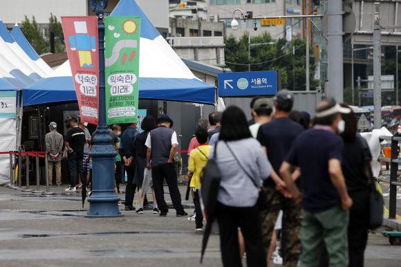 28일 오전 서울 중구 서울역광장에 마련된 신종 코로나바이러스 감염증(코로나19) 선별검사소를 찾은 시민들이 검사를 위해 줄 서 있다. 뉴스1