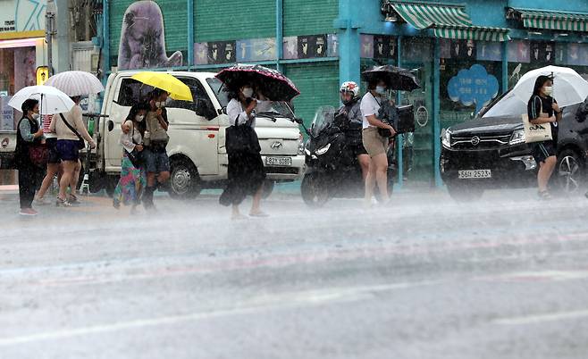 28일 오후 서울 마포구 홍대입구역 인근에서 시민들이 갑자기 내리는 비를 피하고 있다. / 장련성 기자