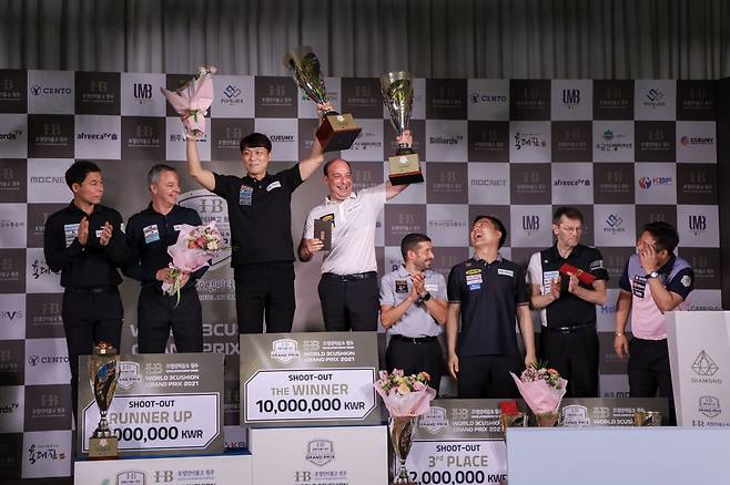 우승한 산체스-최성원 팀이 시상대에 서서 트로피를 번쩍 치켜들고 있다. 2위 딕 야스퍼스-허정한 팀과 공동 3위팀이 박수를 치며 축하해 주고 있다. [파이브앤식스 제공]