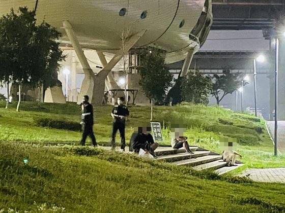 서울시가 10시 이후 야외음주 금지 행정명령을 발표한 6일, 한강사업본부 직원들이 시민들에게 음주 계도를 하고 있다. 계도 후에도 불응, 음주를 계속하면 10만원의 과태료가 부과될 수 있다. 허정원 기자.