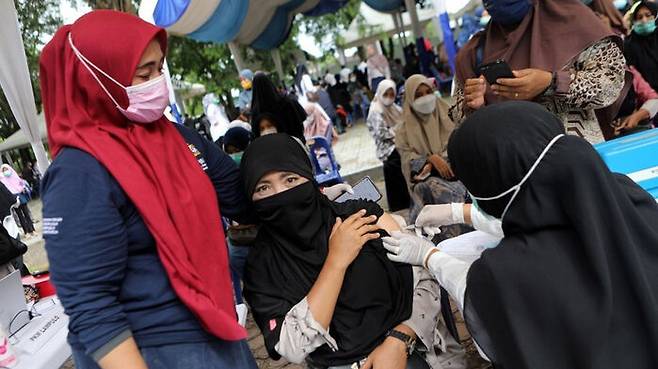 인도네시아에서 한 여성이 시노백 백신을 맞고 있다.(출처=사우스차이나모닝포스트)