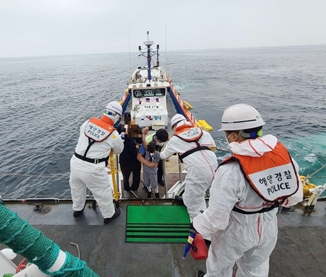 목포해경이 신안군 가거도에서 복통을 호소한 A군을 해상에서 민간해양구조선에 의해 인계받고 있다. (사진=목포해양경찰서 제공)