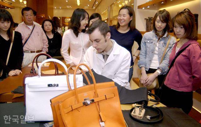2004년 프랑스 에르메스 본사에서 온 '장인' 제라미 부이소(가운데)가 한국 고객들에게 버킨백과 켈리백 제작 과정을 공개해 선보이고 있다. 한국일보 자료사진