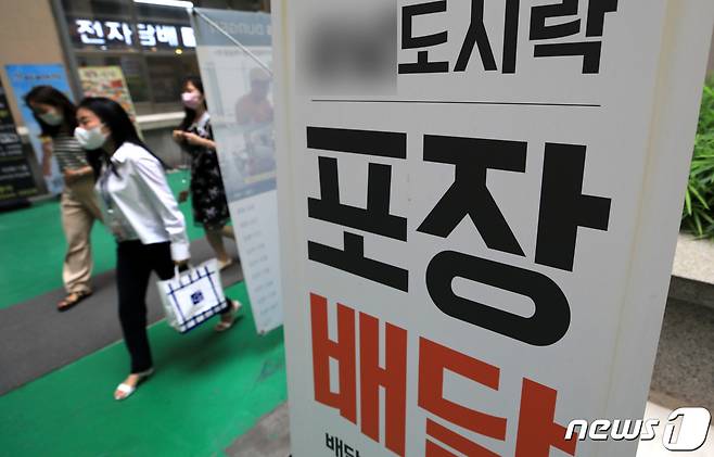 수도권 지역에 사회적 거리두기 4단계가 시작된 12일 서울 여의도의 한 식당에서 시민들이 음식을 포장한 음식을 들고 음식점을 나서고 있다.© News1 구윤성 기자