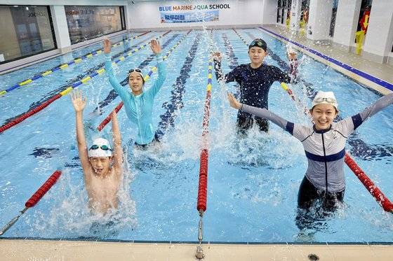 물놀이 안전수칙에 따라 생존 수영을 배우기 전 물속에서 다양한 동작을 취하며 몸을 풀고 있는 소중 학생기자단.