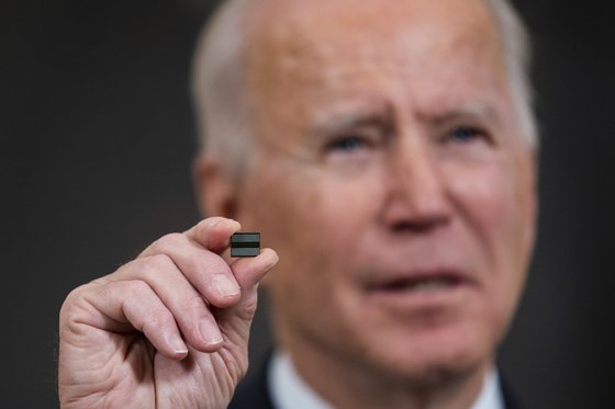 미국의 조 바이든 대통령이 지난 2월 백악관에서 반도체·전기차배터리·희토류 등 주요 물자의 공급망 점검을 지시하는 행정명령에 서명하기 전 반도체 칩을 들어 보이고 있다.[EPA]
