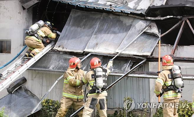 구조물 걷어내는 소방대원 (광주=연합뉴스) 천정인 기자 = 12일 오전 광주 광산구 우산동 한 생활용품창고에서 불이 나 소방대원들이 진화 작업을 하고 있다. 2021.7.12 iny@yna.co.kr