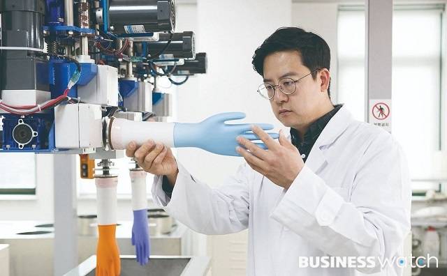금호석유화학 연구원이 NBL로 만든 장갑을 점검하고 있다./사진=금호석화 제공