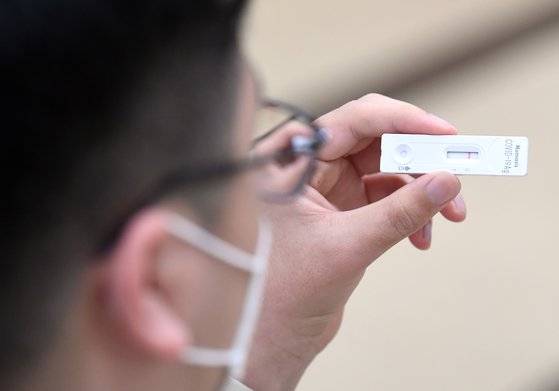 지난달 자가 검사를 마친 한 시민이 음성 반응을 보이는 테스트기를 확인하고 있다. *기사내용과 직접적인 관련 없습니다. 연합뉴스