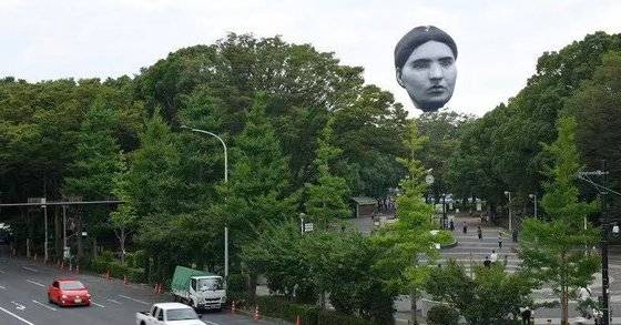 공공미술 열기구 ‘마사유메’(正夢)가 16일 일본 도쿄 요요기공원 나무숲 사이로 떠오르고 있다. [트위터 캡처]