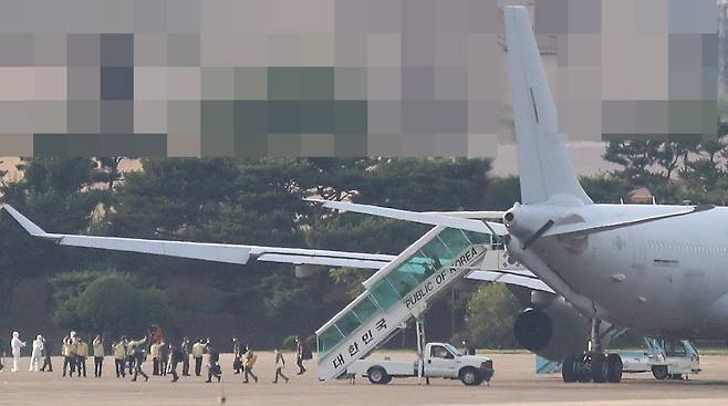 해외파병 중 코로나19가 집단발병한 청해부대 제34진 장병들이 공군 다목적 공중급유수송기 KC-330 '시그너스'를 타고 20일 오후 경기 성남시 서울공항에 도착, 기내에서 내려 차량으로 이동하고 있다./뉴시스