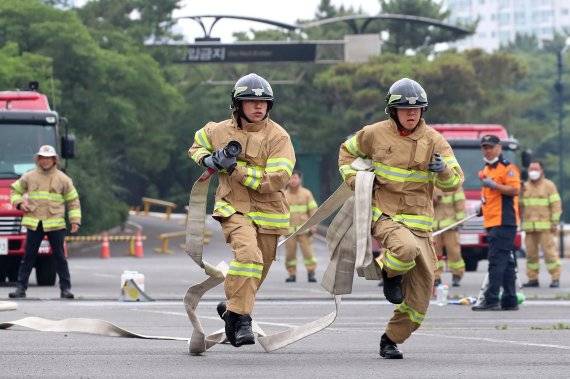 지난 6월23일 대구에서 열린 2021년 화재진압분야 소방기술경연대회에 참가한 소방관들이 목표물을 향해 힘차게 달려가고 있다. 뉴스1