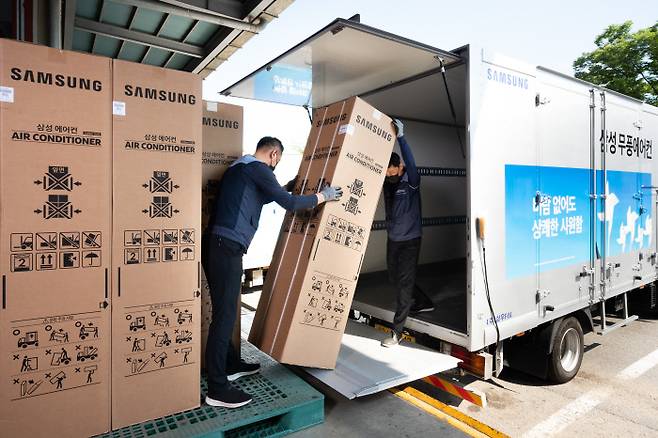 삼성전자로지텍 직원들이 23일 경기 수원시 물류창고에서 에어컨 제품을 차량에 싣고 있다. 연합뉴스