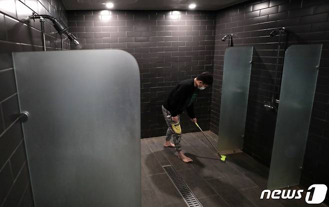 (서울=뉴스1) 이성철 기자 = 29일 서울 강남구의 한 헬스장에서 관계자가 샤워실을 청소하고 있다. 정부 방역수칙에 따르면 헬스장은 오후 9시까지 영업이 허용되는 대신 샤워시설 이용은 제한된다. 반면 골프장과 수영장 샤워실은 이용이 가능해 형평성 논란이 일고 있다. 2021.1.29/뉴스1