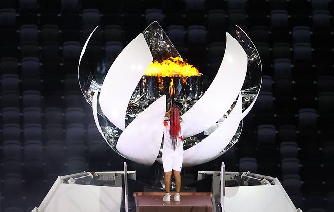 여자 테니스 세계랭킹 2위인 일본 오사카 나오미가 23일 일본 도쿄 신주쿠 국립경기장에서 열린 2020 도쿄올림픽 개막식에서 성화대에 불을 점화하고 있다. /연합뉴스