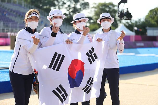 25일 일본 유메노시마 공원 양궁장에서 열린 도쿄올림픽 여자 양궁 단체전 경기에서 금메달을 획득한 여자 양궁 대표팀이 태극기를 들고 포즈를 취하고 있다./연합뉴스