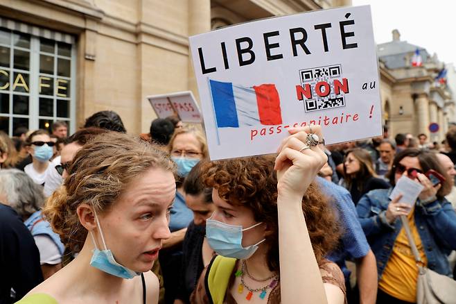 17일(현지 시각) 프랑스 파리에서 정부의 코로나19 백신 접종 의무 확인 지침에 반대하는 시위대가 '자유'라는 글귀가 적힌 팻말을 들고 시위를 벌이고 있다. /로이터 연합뉴스