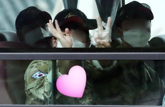 지난 20일 오후 청해부대 장병을 태운 버스가 성남 서울공항을 빠져나와 의료 시설로 출발하고 있다. 이날 버스에 탄 청해부대 장병이 취재진을 향해 손을 흔들고 있다. 사진 뉴스1