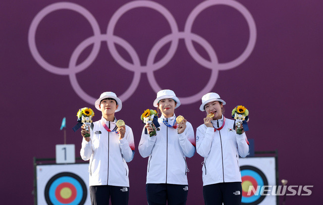 [도쿄(일본)=뉴시스] 최진석 기자 = 대한민국 양궁 대표팀 안산, 장민희, 강채영이 25일 오후 일본 도쿄 유메노시마 양궁장에서 열린 2020 도쿄올림픽 양궁 여자단체전 시상식에서 금메달 세리머니를 하고 있다. 2021.07.25. myjs@newsis.com