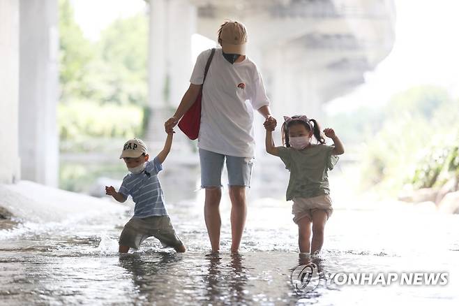 이렇게라도 낮 기온이 35도 안팎에 이르는 무더위가 이어진 지난 21일 오후 서울 홍제천에서 엄마와 아이들이 더위를 식히고 있다. [연합뉴스 자료사진]