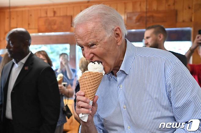 조 바이든 미국 대통령이 2021년 7월 3일(현지시간) 인프라 투자 합의 홍보차 미시간주 트래버스 시티를 방문하던 중 아이스크림을 사서 먹고 있다. 주변엔 마스크를 쓰지 않은 사람들의 모습이 보인다. © AFP=뉴스1 © News1 우동명 기자