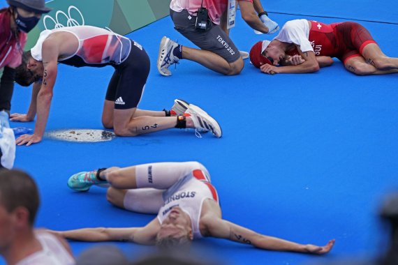 26일 일본 도쿄에서 열린 하계 올림픽 남자 3종 경기를 마친 선수들이 결승선 통과후 지친 나머지 바닥에 드러눕고 있다.AP뉴시스