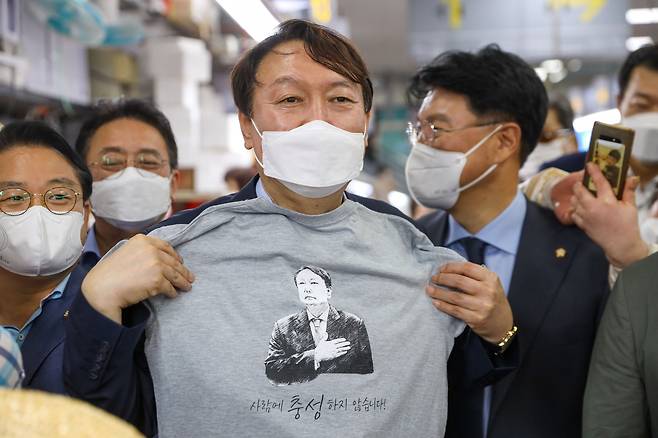 야권 대선주자인 윤석열 예비후보가 27일 부산 자갈치시장에서 지지자들이 선물한 티셔츠를 들고 있다. /윤석열 캠프 제공