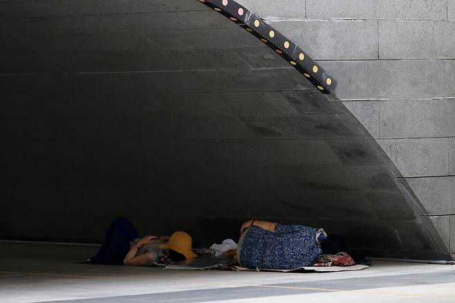 폭염이 계속되고 있는 가운데 27일 오후 서울 종로구 청계천 모전교 아래 그늘에서 시민들이 잠을 자고 있다. 연합뉴스