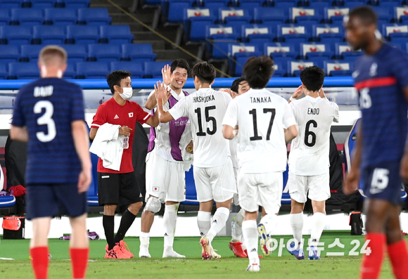 일본 선수들이 28일 오후 일본 요코하마 국제 종합경기장에서 진행된 '2020 도쿄올림픽' 남자축구 조별리그 A조 3차전 일본과 프랑스의 경기에서 4-0으로 승리한 후 하이파이브를 하고 있다.
