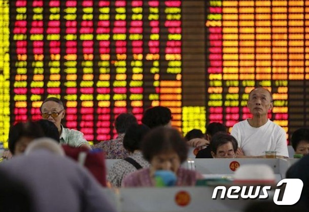 상하이증권거래소에서 투자자들이 전광판을 지켜보고 있다.© 로이터=뉴스1