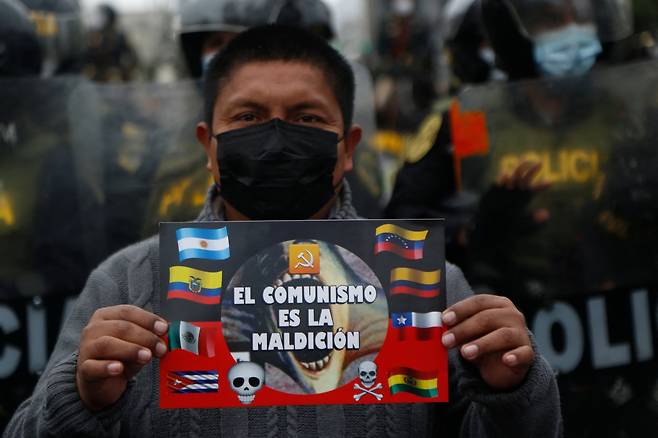 페드로 신임 대통령에 반대하는 페루 시민이 28일 리마에서 '사회주의는 저주'라고 쓴 피켓을 들고 시위를 벌이고 있다. AFP=연합뉴스