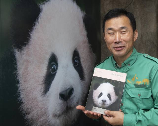 강철원 에버랜드 사육사가 책 ‘아기 판다 푸바오’를 들고 환하게 웃고 있다./사진제공=에버랜드