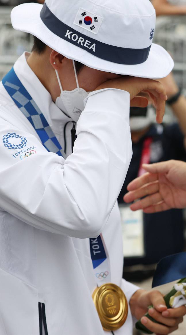 안산이 30일 일본 유메노시마 공원 양궁장에서 열린 도쿄올림픽 양궁 여자 개인전 결승에서 승리해 금메달을 목을 걸고 시상대를 나오던 중 정의선 현대차그룹 회장의 축하를 받자 눈물을 보이고 있다. 도쿄 | 연합뉴스