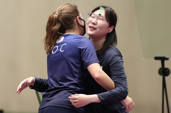 Vitalina Batsarashkina (left) and Kim Min-jung hug after the women's 25-meter pistol final during the shooting event at the 2020 Olympic at Asaka Shooting Range on Friday. [TASS/YONHAP]